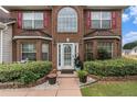 Inviting front entryway with decorative door, well-kept landscaping, and brick accents at 11961 Markham Way, Hampton, GA 30228