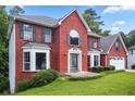 Traditional brick home featuring an attached garage and green shutters, all situated on a well-manicured lawn at 1553 Smithson Ct, Lithonia, GA 30058