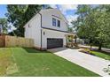 Side view of a modern farmhouse style home with green grass and a partial view of a wood fence at 3155 Zion St, Scottdale, GA 30079