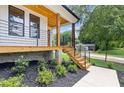 Inviting porch with wood ceiling, metal railings and stylish staircase leading to the entrance at 3155 Zion St, Scottdale, GA 30079