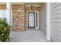 Close-up of the inviting front door with decorative glass and stone detailing on the facade at 4420 Ambassador Way, Cumming, GA 30040