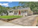 Charming bungalow with red front door, a front porch and long driveway at 1667 Sylvan Sw Rd, Atlanta, GA 30310