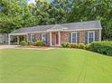 Charming brick home features a covered carport, well-kept lawn and manicured shrubs at 365 Norcross St, Roswell, GA 30075