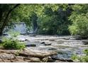 Scenic view of a river cascading over rocks, surrounded by lush greenery at 365 Norcross St, Roswell, GA 30075