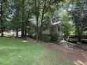 Suburban home with long driveway and side entry garage in a wooded setting at 390 Hunt River Way, Suwanee, GA 30024