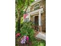 Inviting front porch with colorful flowers, decorative plants, and an American flag at 3788 Westwick Nw Ct, Kennesaw, GA 30152