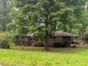 Traditional brick home with a mature tree in the front yard providing shade and curb appeal at 4485 Canary Ct, Lithia Springs, GA 30122
