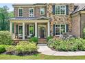 Charming front porch with seating area and meticulous landscaping at 6470 Long Island Nw Dr, Atlanta, GA 30328
