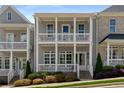 Charming townhome featuring a double front porch, a gray facade, and manicured landscaping at 2125 Parkside Ln, Roswell, GA 30076