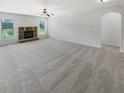 Bright living room features a stone fireplace, ceiling fan, and large windows at 622 Madison Park Dr, Grayson, GA 30017
