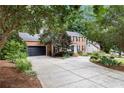 Two-story brick home features a long driveway, attached garage, and landscaped front yard at 1379 Cambridge Ne Ct, Brookhaven, GA 30319