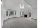 Open living room features soaring ceilings, fireplace, and lots of windows at 2231 Mill Garden Pl, Buford, GA 30519