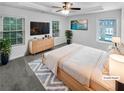 Cozy main bedroom with a tray ceiling, large windows, and neutral décor at 2231 Mill Garden Pl, Buford, GA 30519