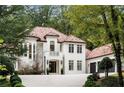 Elegant two-story home with a red tile roof, white exterior and lush landscaping at 3401 Stillhouse Se Rd, Atlanta, GA 30339