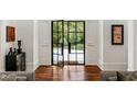 Elegant foyer featuring a black steel and glass front door, wood floors and detailed trim at 3401 Stillhouse Se Rd, Atlanta, GA 30339
