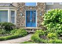 Close up of a beautiful blue double-door entrance framed by stone and lush greenery at 5807 Brookstone Nw Walk, Acworth, GA 30101