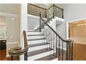Elegant staircase featuring dark wood steps, white risers, and decorative iron railings at 5807 Brookstone Nw Walk, Acworth, GA 30101