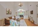 Bright living room featuring high ceilings, chandelier, wood floors, and open to the dining room at 845 Melbourne Trl, Alpharetta, GA 30009