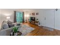 Comfortable living room with hardwood floors, gray sofa, and sliding glass doors to a balcony at 3135 Seven Pines Ct # 201, Atlanta, GA 30339