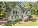 Charming split-level home with green siding, black shutters, and a side two-car garage with a driveway at 94 Park W Ave, Dallas, GA 30157