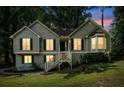 Charming split-level home with green siding, black shutters, and a inviting front entrance, with sunset backdrop at 94 Park W Ave, Dallas, GA 30157