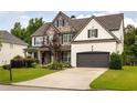 Beautiful two-story home with a combination of stone and brick, lush landscaping, and attached two-car garage at 374 Heritage, Woodstock, GA 30188