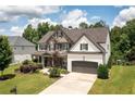 Beautiful two-story home featuring a combination of stone and brick, well-manicured lawn, and an attached two-car garage at 374 Heritage, Woodstock, GA 30188