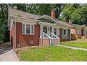 Classic brick home showing the side entry and well-kept front lawn and simple landscaping at 1585 Olympian Sw Cir, Atlanta, GA 30310