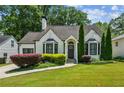 Charming home featuring a brick facade, manicured lawn, and lush landscaping at 2545 Tilson Se Dr, Atlanta, GA 30317