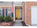 Inviting front entrance featuring a bright yellow door, brick facade, and charming decorative accents at 3427 Hampreston Nw Way, Kennesaw, GA 30144