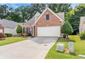 Lovely brick home with green lawn and garden, and a paved driveway leading to an attached garage at 3427 Hampreston Nw Way, Kennesaw, GA 30144