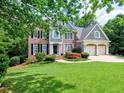 Lovely two-story brick home with a manicured lawn, colorful landscaping, and a two-car garage at 658 Vinings Estates Se Dr, Mableton, GA 30126