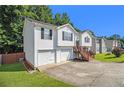 Side view of split-level home with attached garage, wood stairs to front door, and well-manicured lawn at 3372 Springside Rdg, Decatur, GA 30034