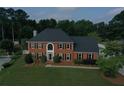 Beautiful two-story brick house with lush green lawn, dark shutters, and arched front door creating a welcoming and elegant entrance at 1197 Kenilworth Trce Trce, Snellville, GA 30078