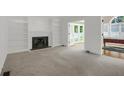 Spacious living room with built-in bookshelves, a cozy fireplace, and adjacent spaces for flexible living and entertaining at 1197 Kenilworth Trce Trce, Snellville, GA 30078
