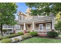 Beautiful two-story home showcasing a spacious front porch, lush landscaping and brick accents at 2165 Parkview Nw Run, Atlanta, GA 30318
