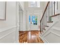 Bright foyer with hardwood floors, detailed trim, staircase, and transom window over the front door at 2165 Parkview Nw Run, Atlanta, GA 30318
