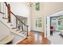 Elegant foyer featuring hardwood floors, staircase with white banister, and a view of the front door with glass panels at 1285 Willow Park Way, Cumming, GA 30041