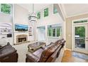 Spacious living room with a stone fireplace, built-in shelving, tall ceilings, and large windows overlooking a green backyard at 1285 Willow Park Way, Cumming, GA 30041