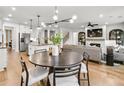 Bright, open-concept living room featuring hardwood floors, modern lighting, and a cozy fireplace at 4660 Rosarian Drive, Cumming, GA 30040