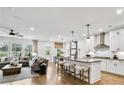 Open-concept living room and kitchen with island seating, stainless appliances, and views of the backyard at 4660 Rosarian Drive, Cumming, GA 30040