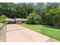Long driveway leads to this traditional style home with mature trees and lush green yard at 2917 Rockingham Nw Dr, Atlanta, GA 30327
