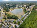Stunning aerial view showcasing a community with houses surrounding a lake and green spaces at 11833 Spring Lake Way, Fayetteville, GA 30215