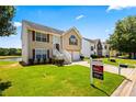 View of two-story home with two-car garage, manicured lawn, and for sale sign at 11833 Spring Lake Way, Fayetteville, GA 30215