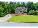 Well-maintained two-story home with a charming covered porch, nestled in a lush, green, and peaceful neighborhood at 5741 Stonekirk Walk Northwest, Acworth, GA 30101