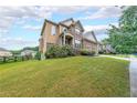 Two-story home with brick and siding, a well-manicured lawn and a welcoming front porch at 1057 Cotton Oak Dr, Lawrenceville, GA 30045