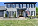 Close up view of the front door showcasing fresh mulch, a beautiful glass door, and an American flag at 1807 N Chestnut Grove Dr, Marietta, GA 30066