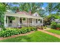 Inviting home showcasing a classic front porch, brick pathway, and lush landscaping at 261 Ormond Se St, Atlanta, GA 30315