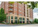 A multi-story brick building with balconies, lush landscaping, and street access, offering urban living at 326 Roswell Se St # 706, Marietta, GA 30060