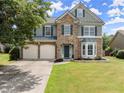 Charming two-story home featuring a stone facade, two-car garage, manicured lawn, and classic curb appeal at 5420 Stevehaven Ln, Cumming, GA 30028